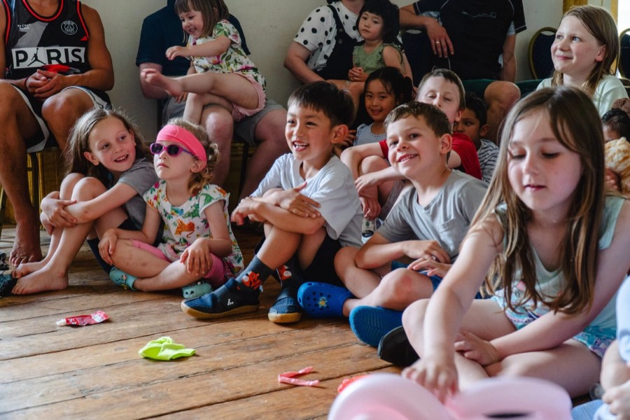 Young children sitting together on a wooden floor
